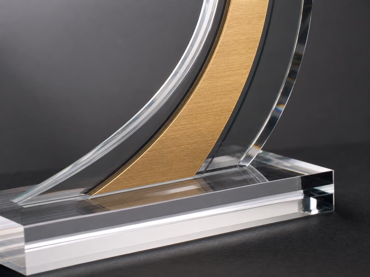 Illustrative close-up of clear acrylic edges and brushed gold accent material