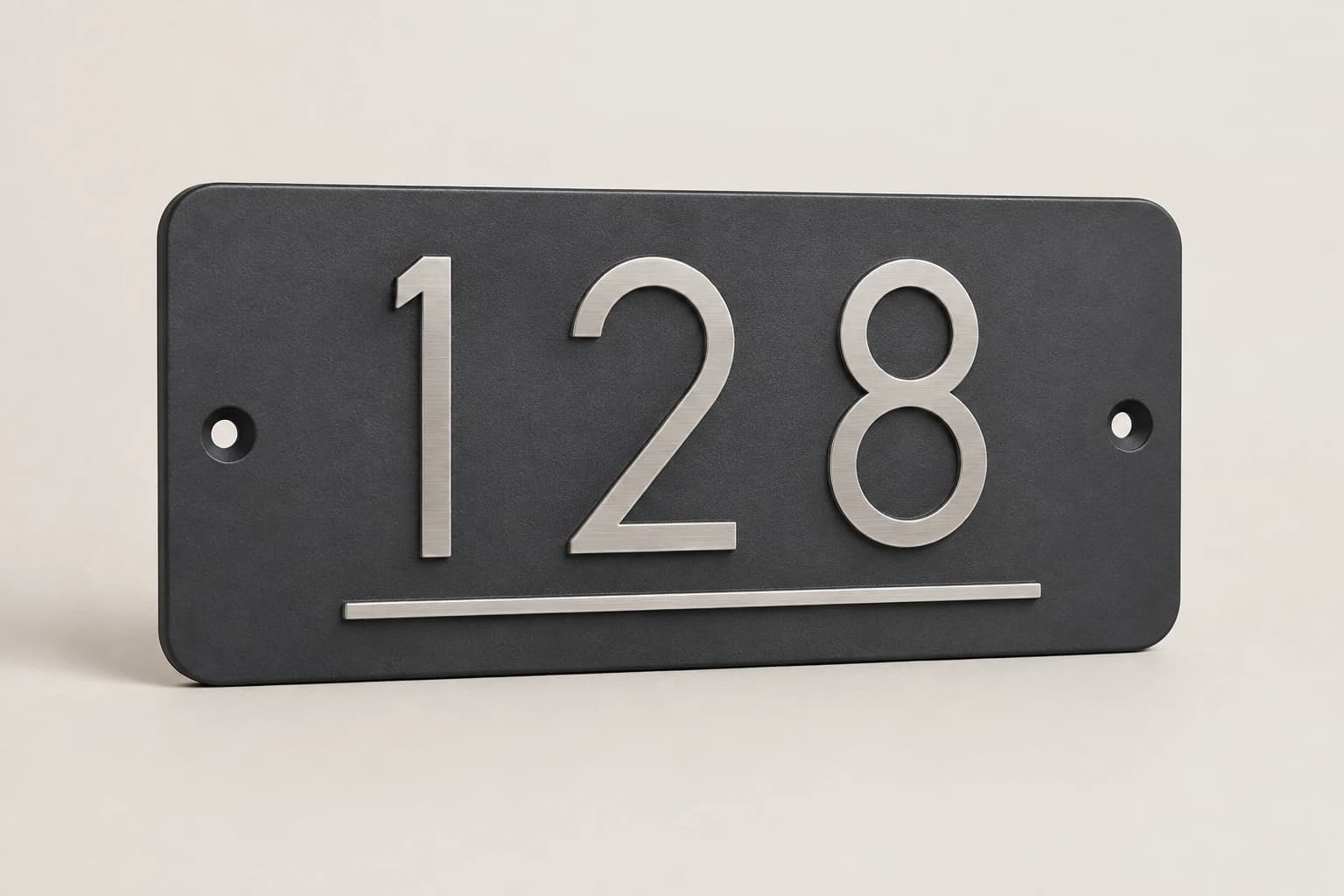 Charcoal house-number plaque with raised brushed-metal numerals.