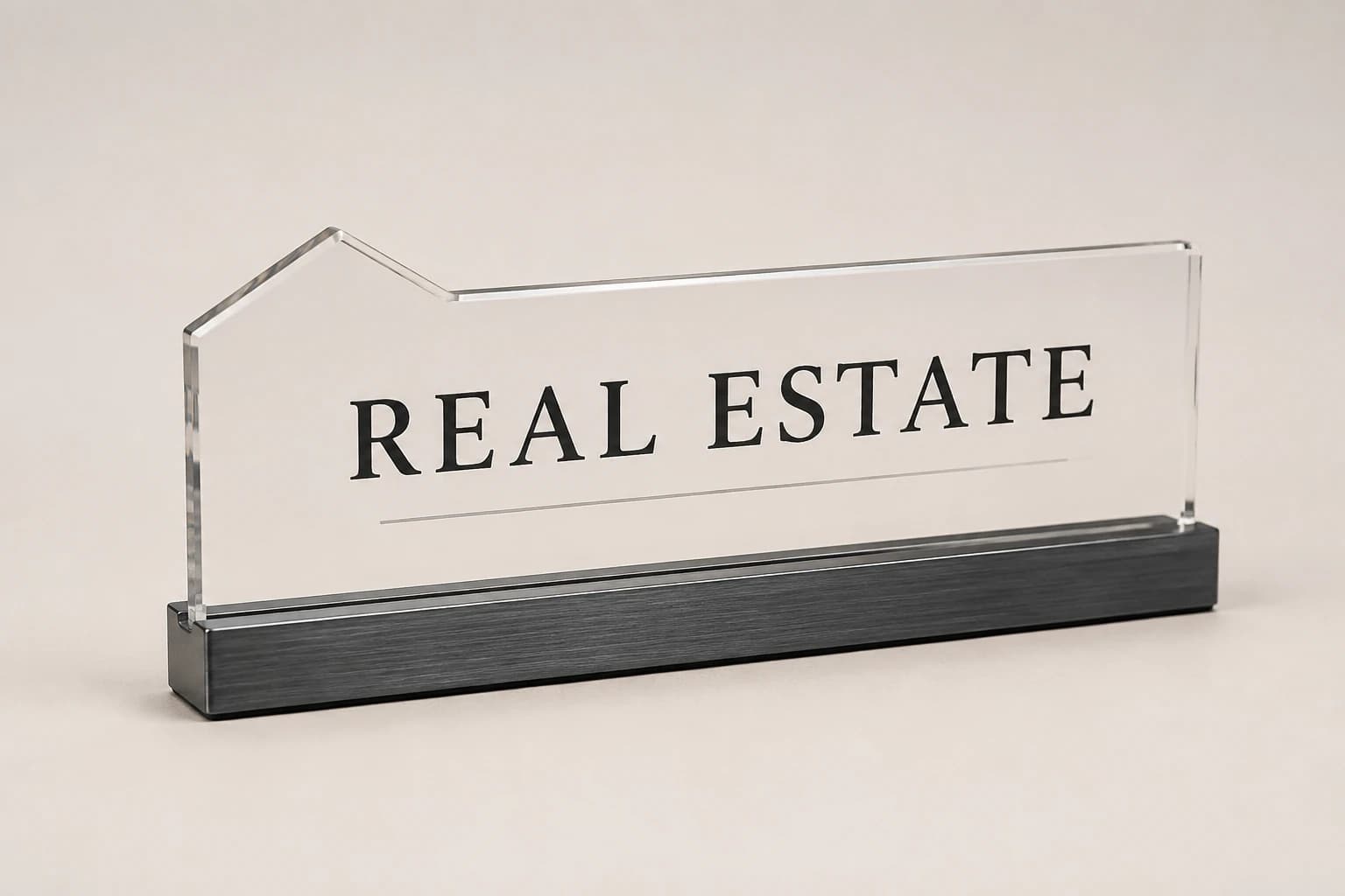 Clear house-profile real-estate desk nameplate in a charcoal base.